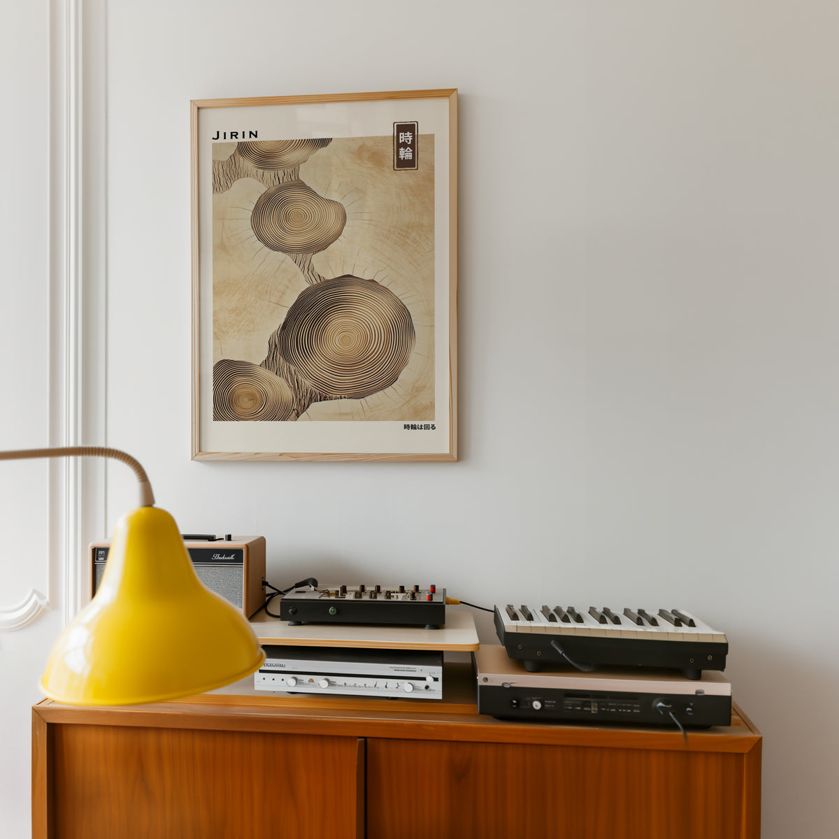 Stacked beige tree ring slices print in an oak frame above a teak sideboard with vintage hi-fi