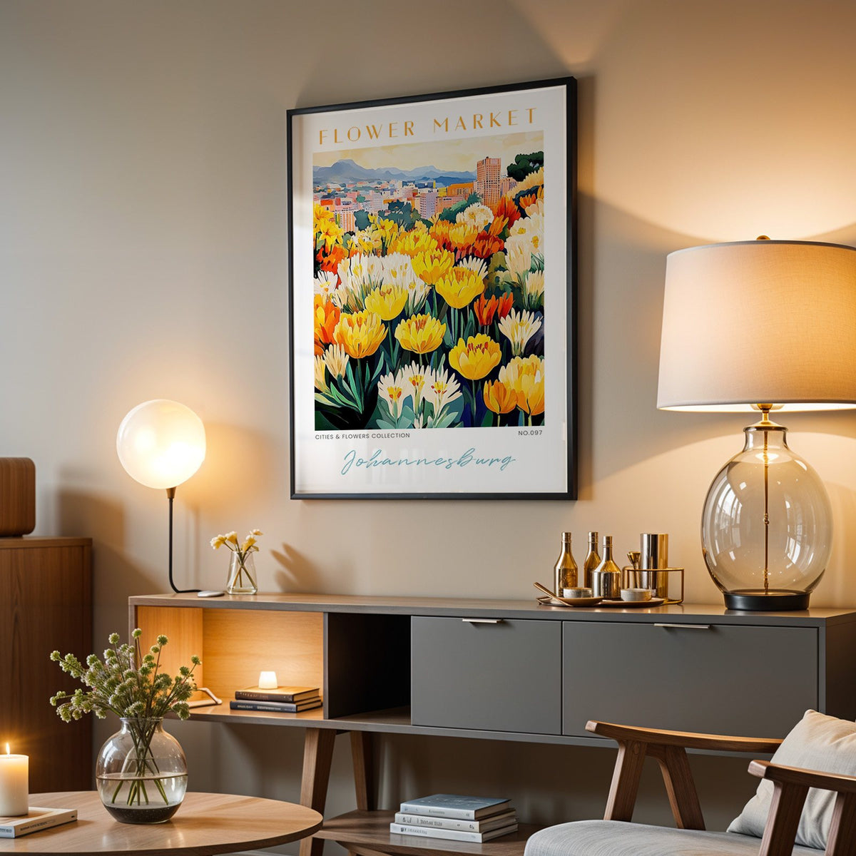 Johannesburg flower market print in a black frame above a grey media console with a glass table lamp