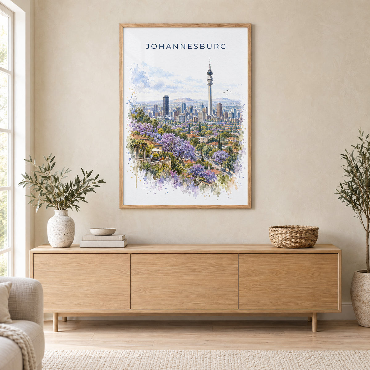Johannesburg watercolor print in an oak frame above a light wood sideboard in a Scandinavian living room
