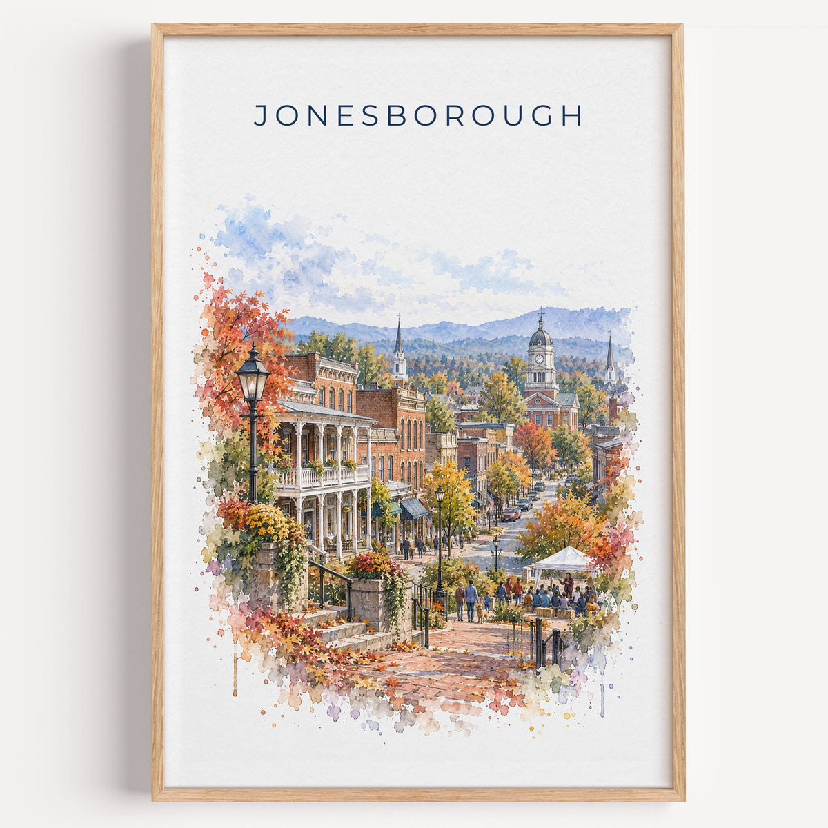 Jonesborough, Tennessee watercolor print in a light oak frame on a plain white wall