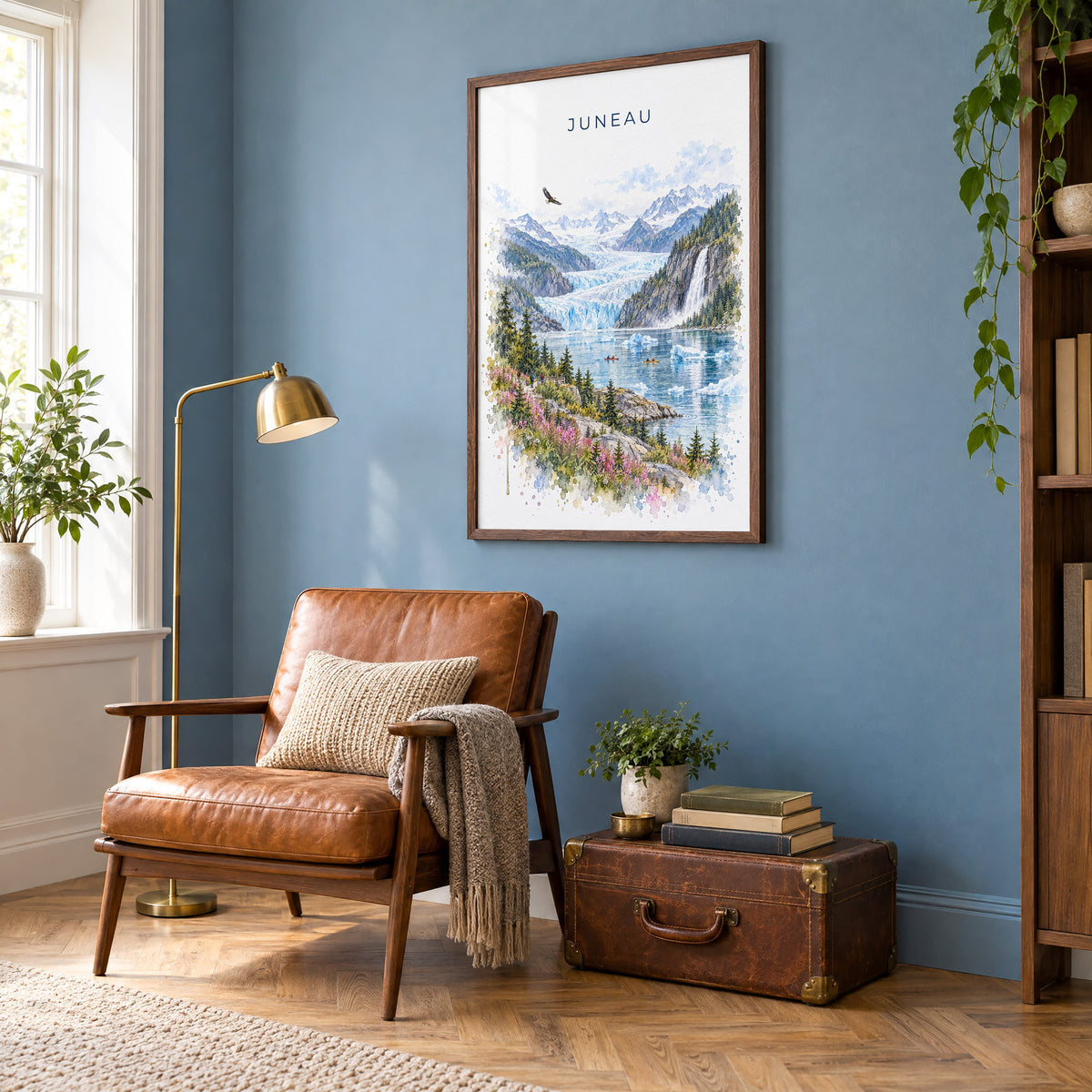 Juneau watercolor print in a walnut frame on a blue wall above a leather armchair in a reading nook