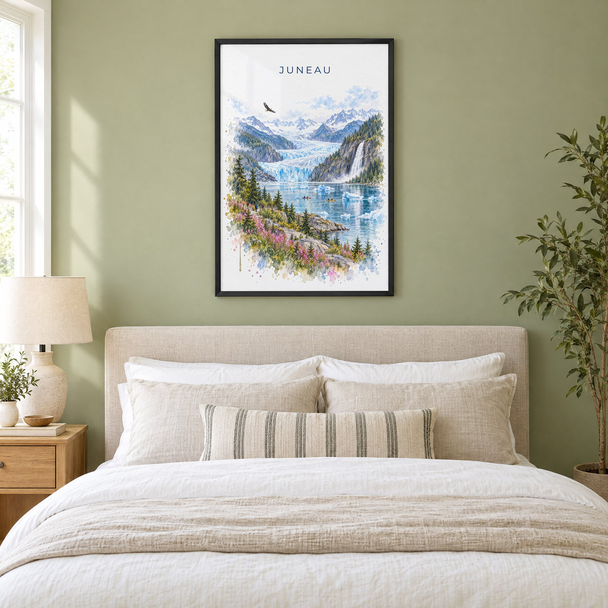 Juneau watercolor print in a black frame above an upholstered headboard in a sage green bedroom