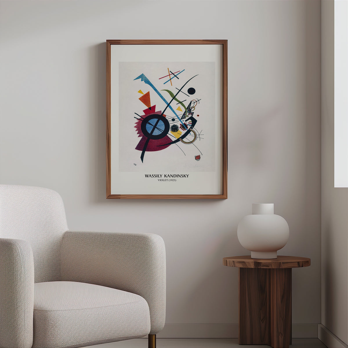 Abstract geometric print in a slim walnut frame above a bouclé armchair