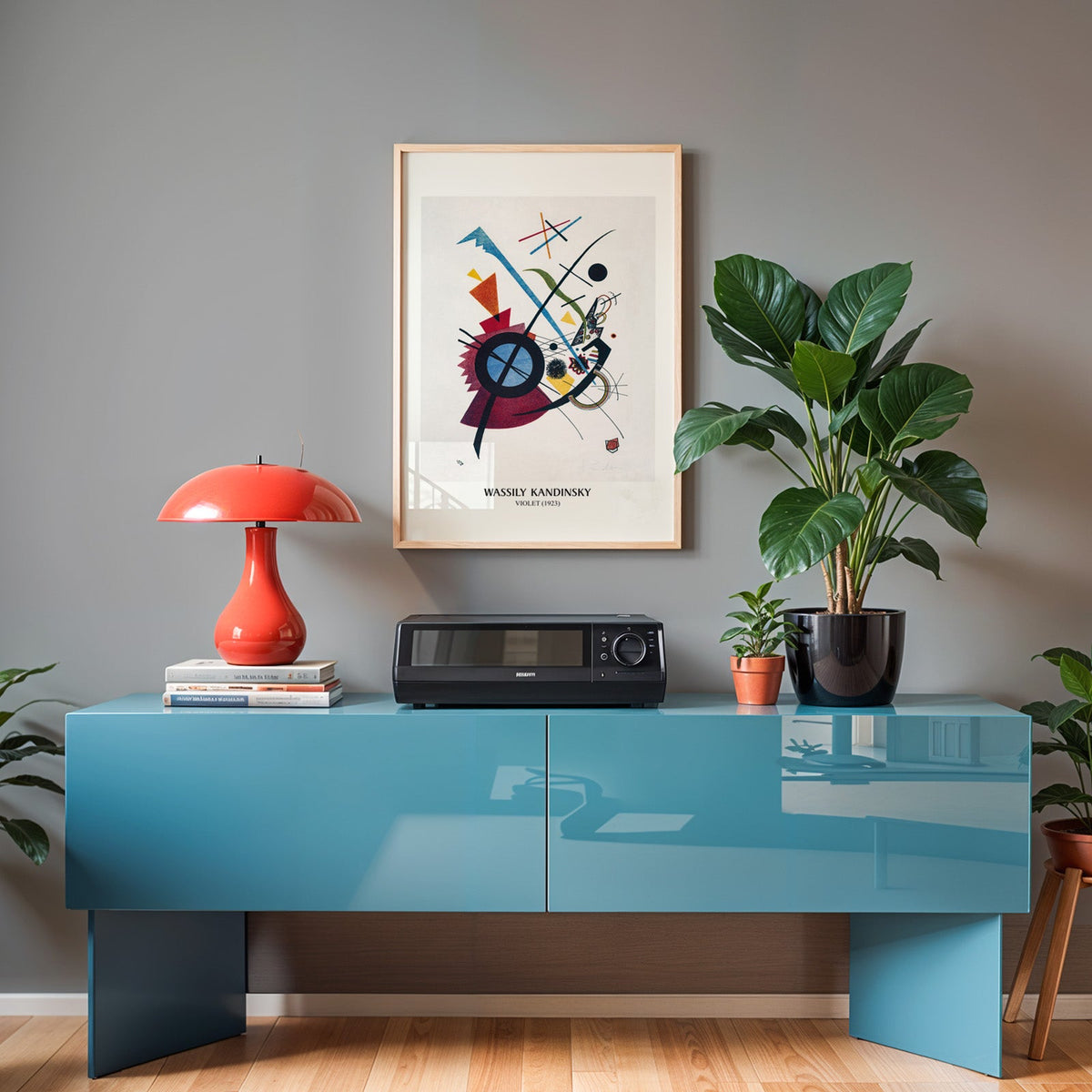Kandinsky print in an oak frame above a teal sideboard with a red lamp