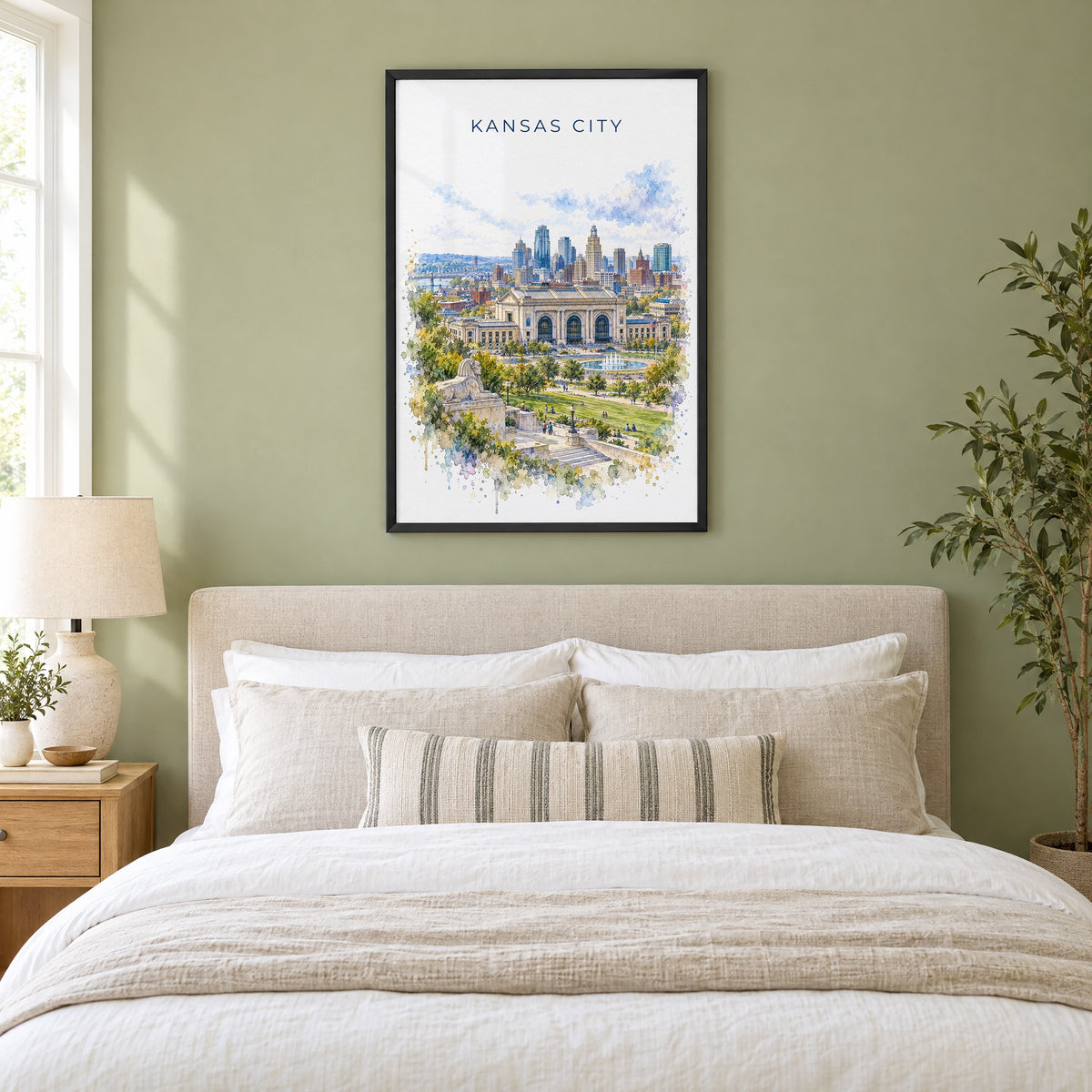 Kansas City watercolor print in a black frame above an upholstered headboard in a sage green bedroom