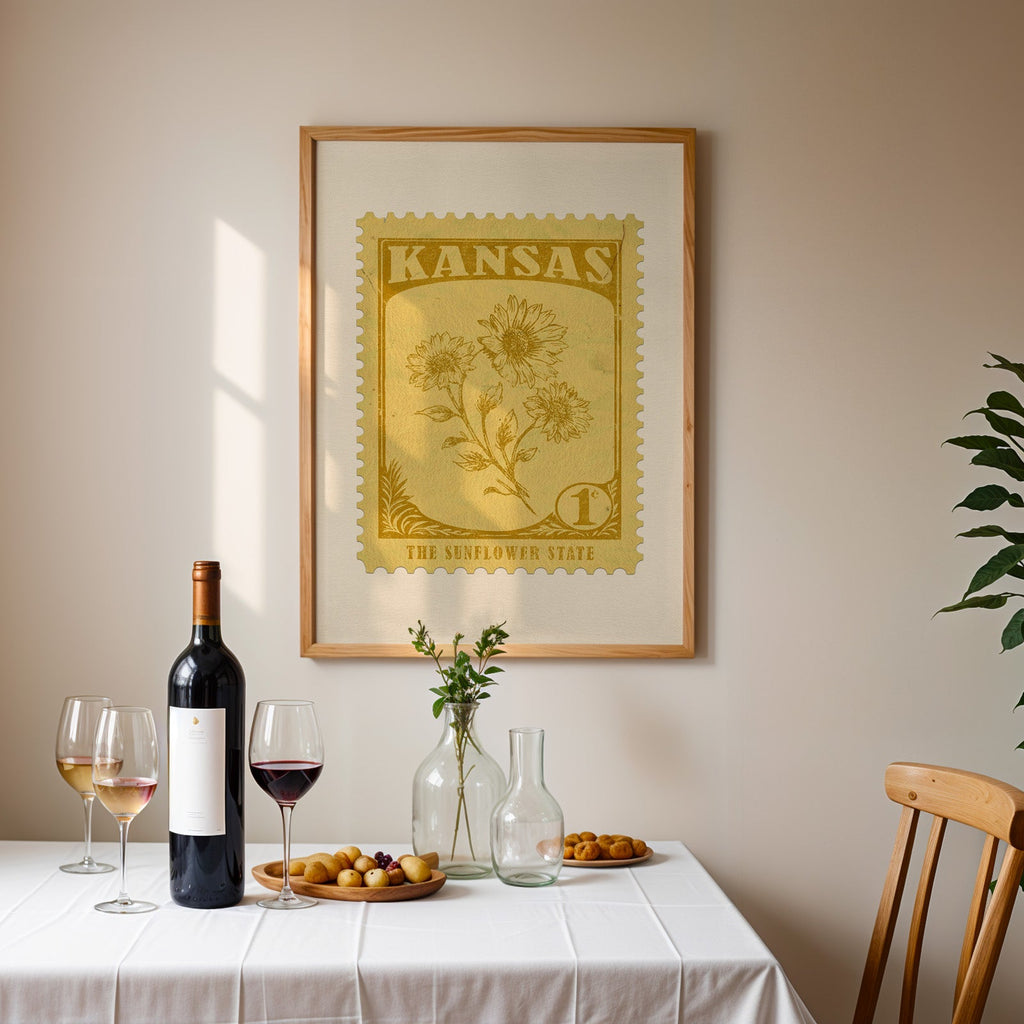Kansas stamp print framed on the wall above a dining table set with wine, glasses and olives