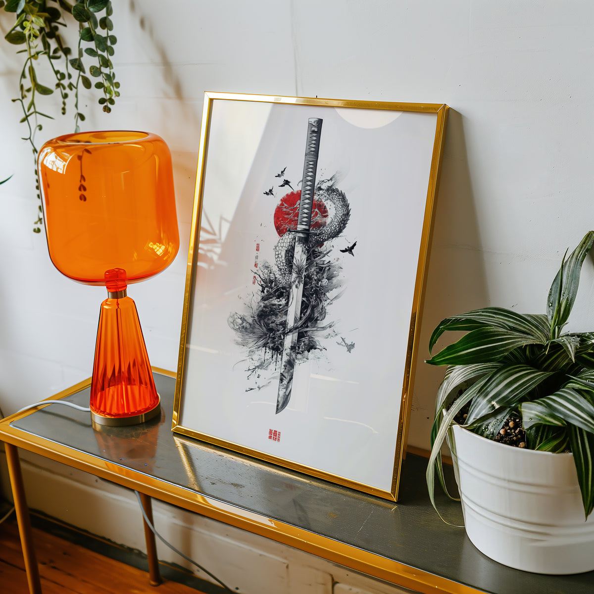 Ink dragon coiled around katana print shown in a gold frame on a console beside an orange glass lamp