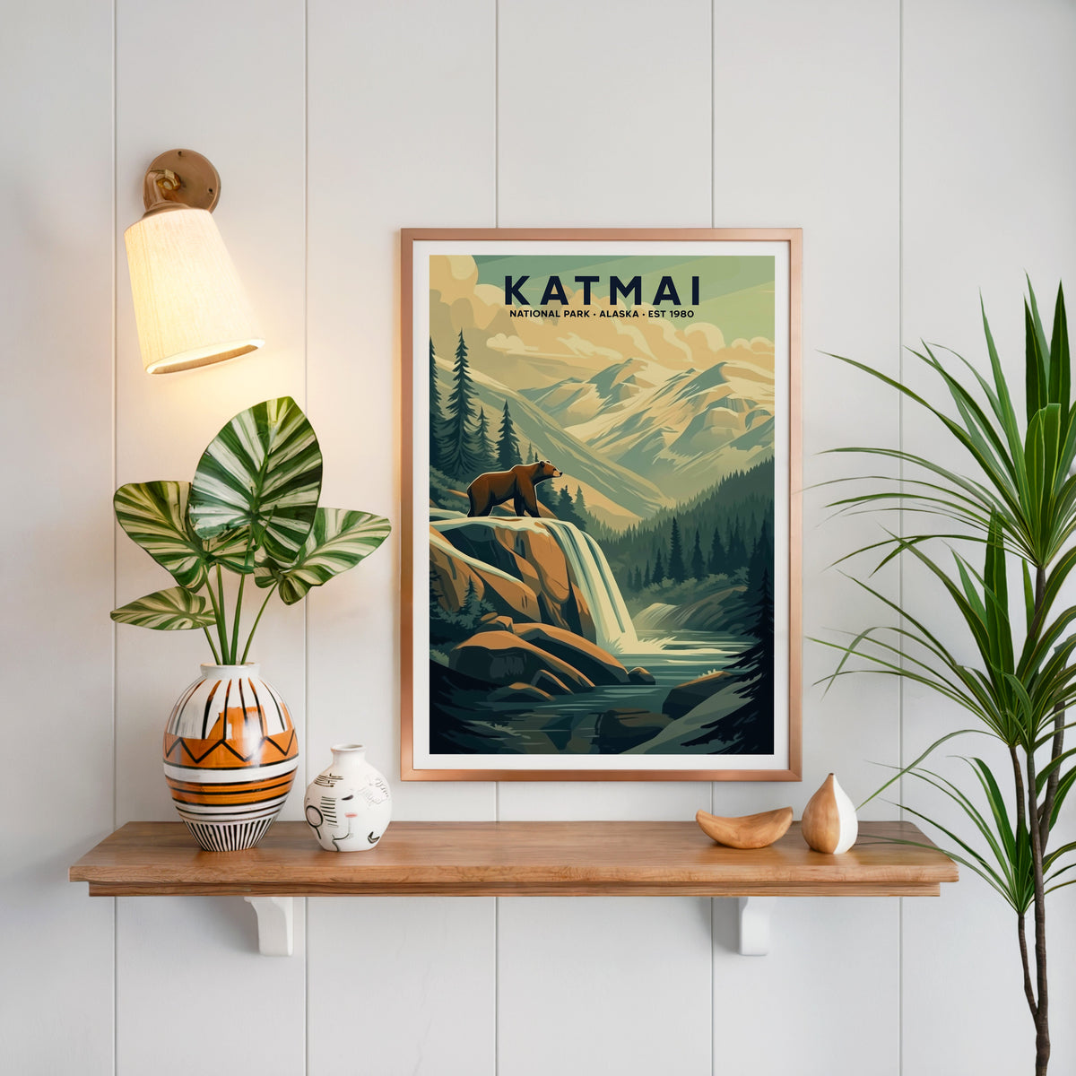 Katmai National Park print in a copper frame above an oak shelf on white shiplap with a brass sconce