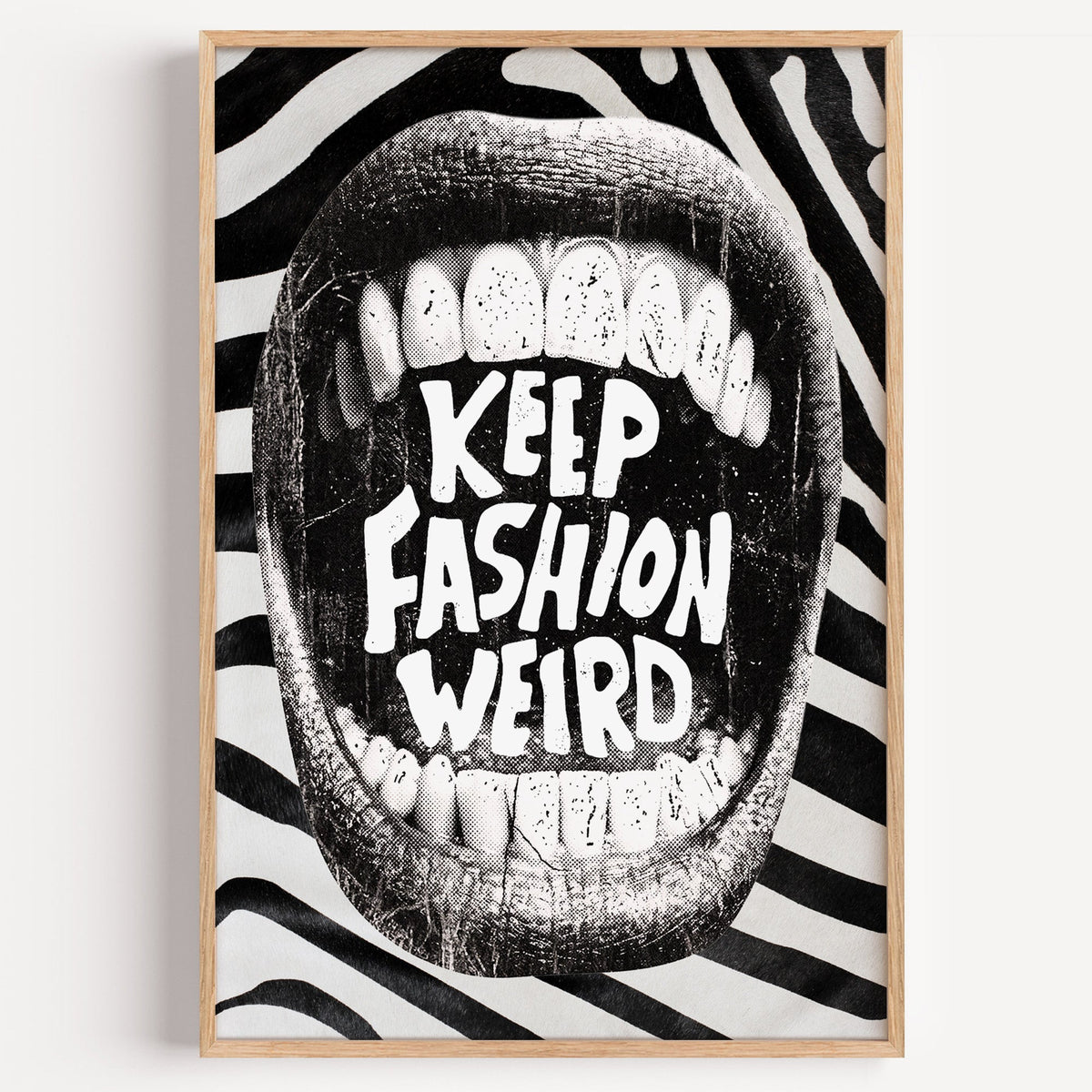 Halftone mouth with Keep Fashion Weird text print in a light oak frame on a plain white wall