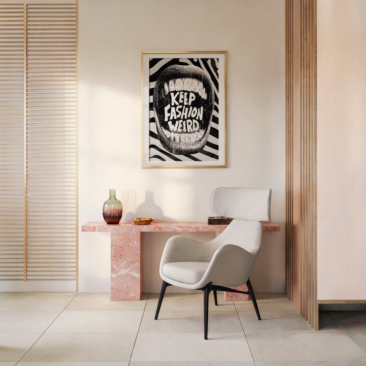 Halftone mouth with Keep Fashion Weird text print shown in a gold frame above a pink marble console and armchair