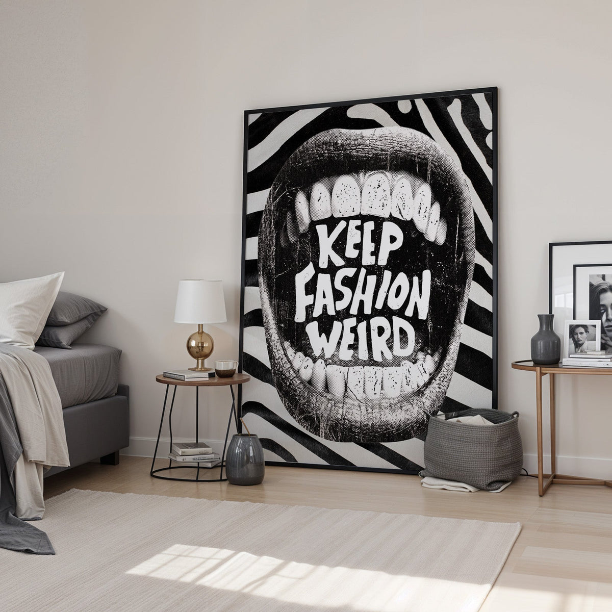 Halftone mouth with Keep Fashion Weird text print in a black frame leaning in a bedroom beside a gold lamp