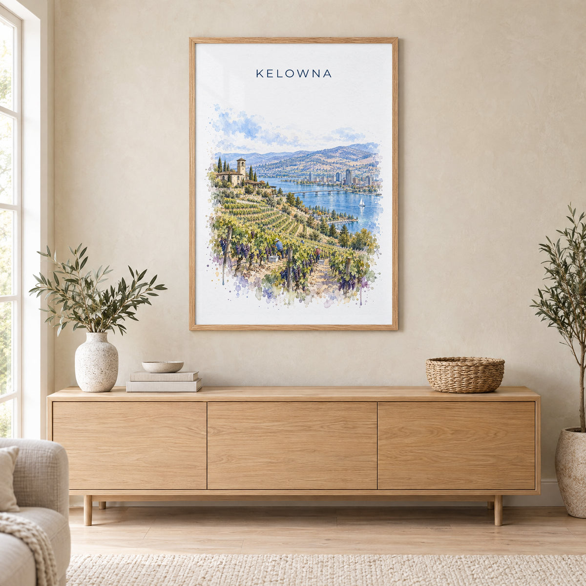 Kelowna watercolor print in an oak frame above a light wood sideboard in a Scandinavian living room