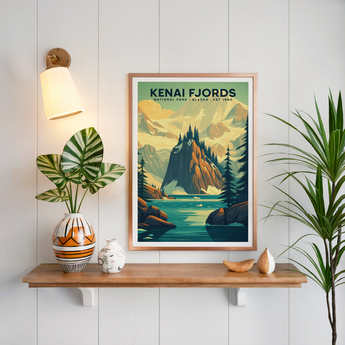 Kenai Fjords National Park print in a copper frame above an oak shelf on white shiplap with a brass sconce
