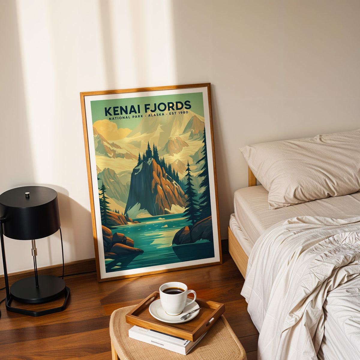 Kenai Fjords National Park print in an oak frame leaning on a bedroom floor beside the bed and a coffee tray