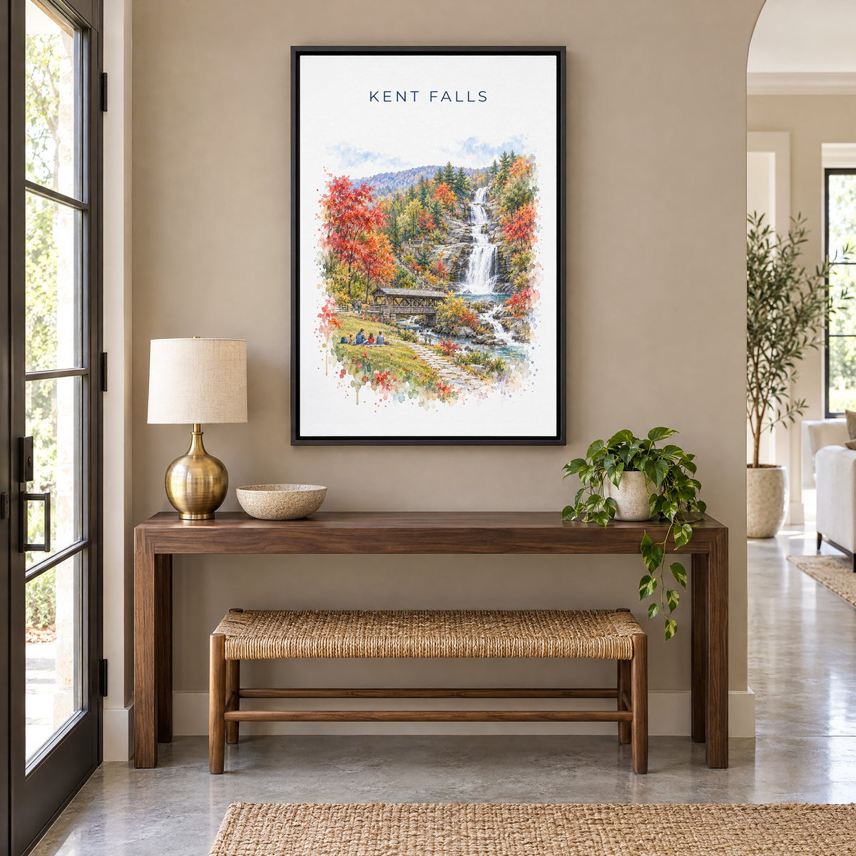 Kent Falls State Park watercolor print as a black floater canvas above a walnut console and woven bench in an entryway