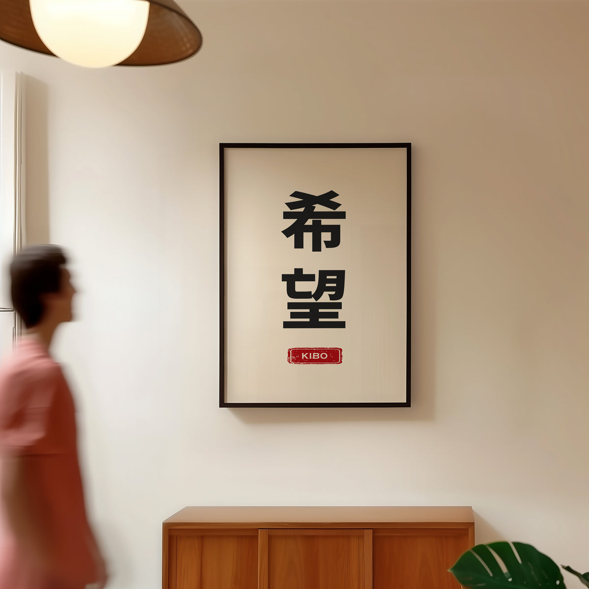 Kibo hope kanji red label print in a black frame in a hallway under a rattan pendant