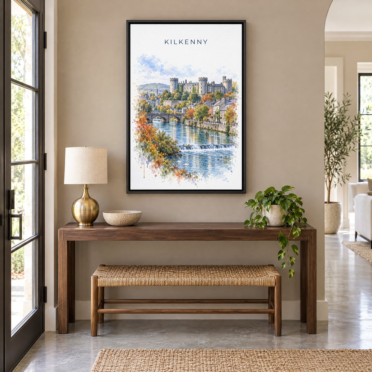 Kilkenny watercolor print as a black floater canvas above a walnut console and woven bench in an entryway