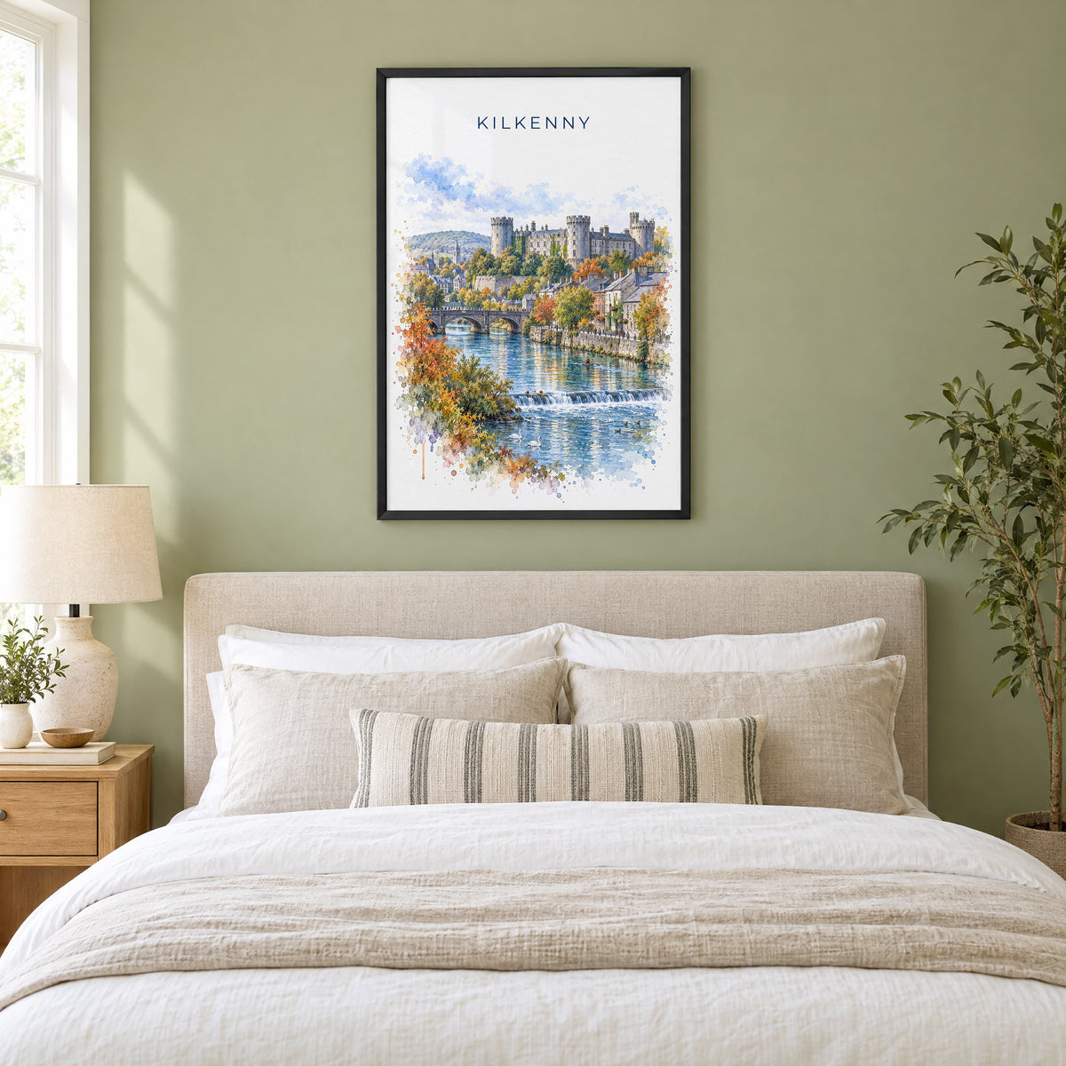 Kilkenny watercolor print in a black frame above an upholstered headboard in a sage green bedroom