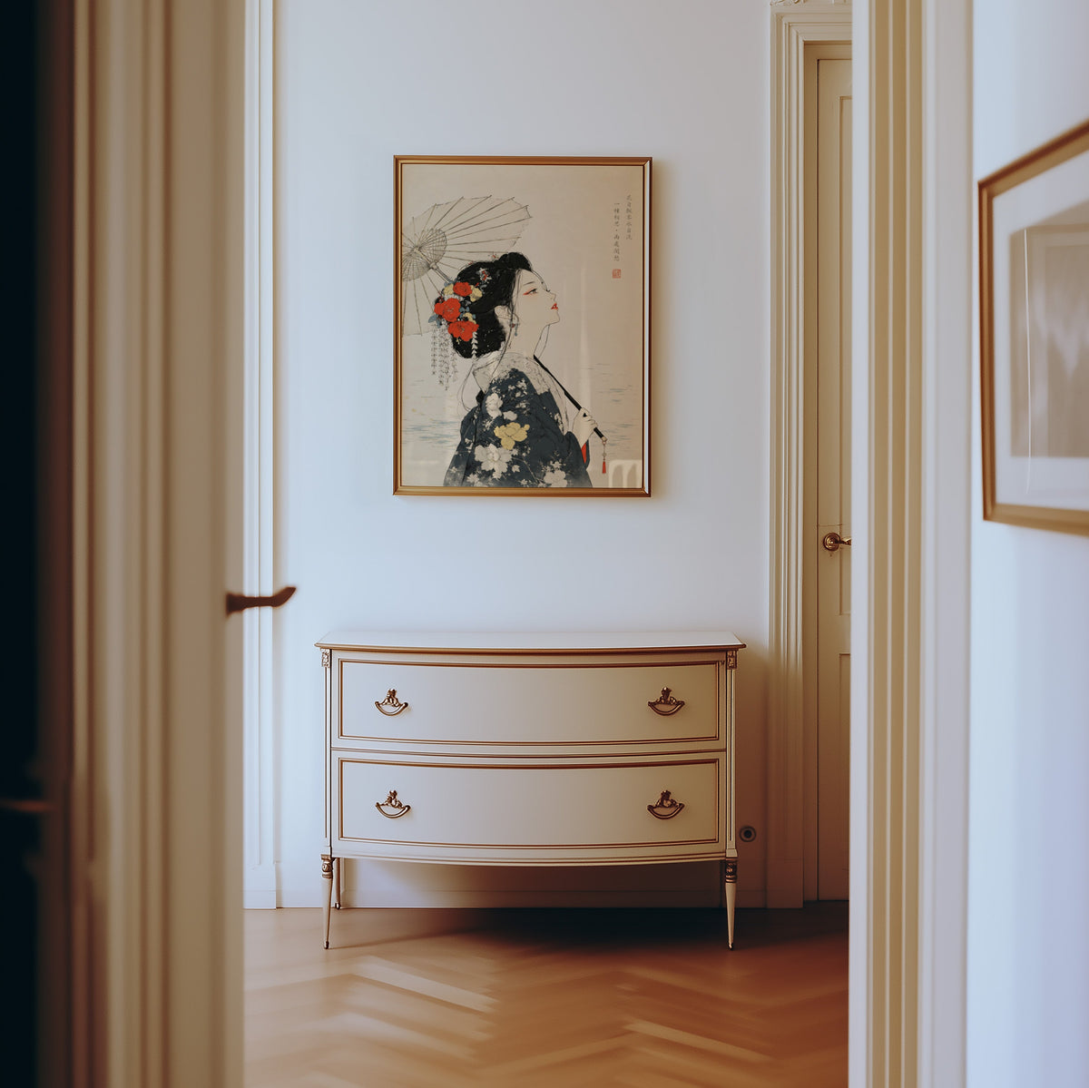 kimono woman with parasol and red flowers print shown in a gold frame in a hallway above a cream dresser