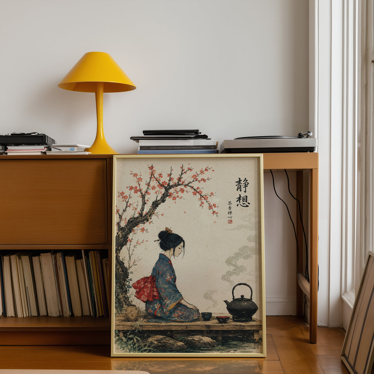 kimono woman with iron tea kettle print shown in a gold frame leaning under a teak desk with a yellow lamp