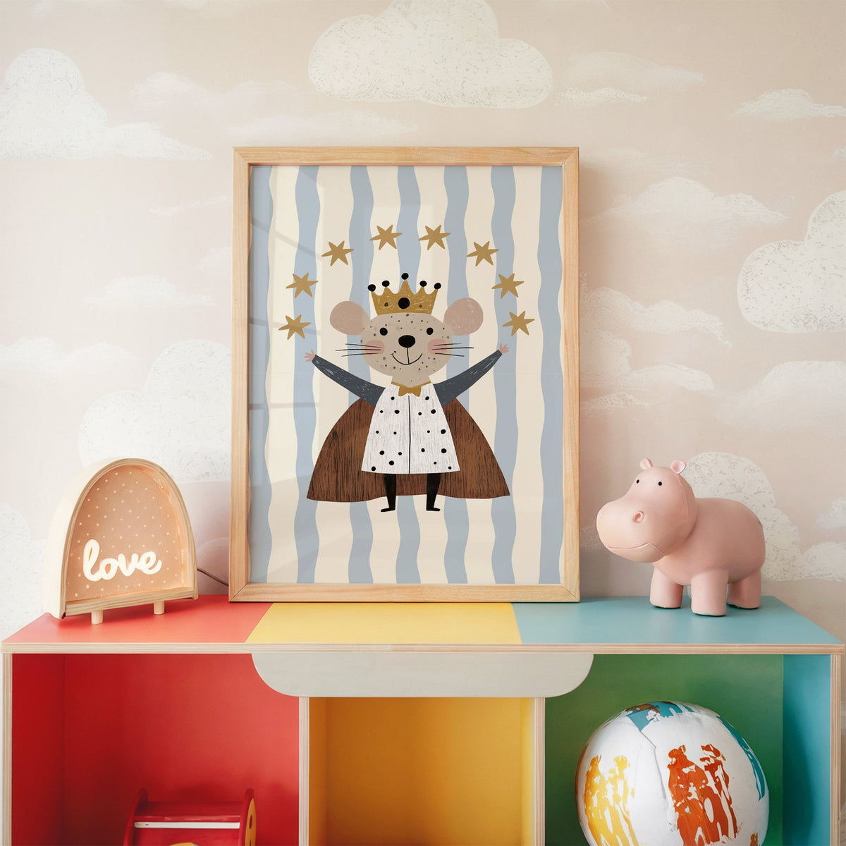King mouse crown star arc nursery print in an oak frame on a rainbow toy shelf against cloud wallpaper