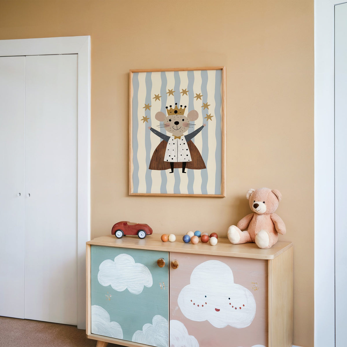 King mouse crown star arc nursery print in an oak frame on a peach wall above a cloud-painted cabinet