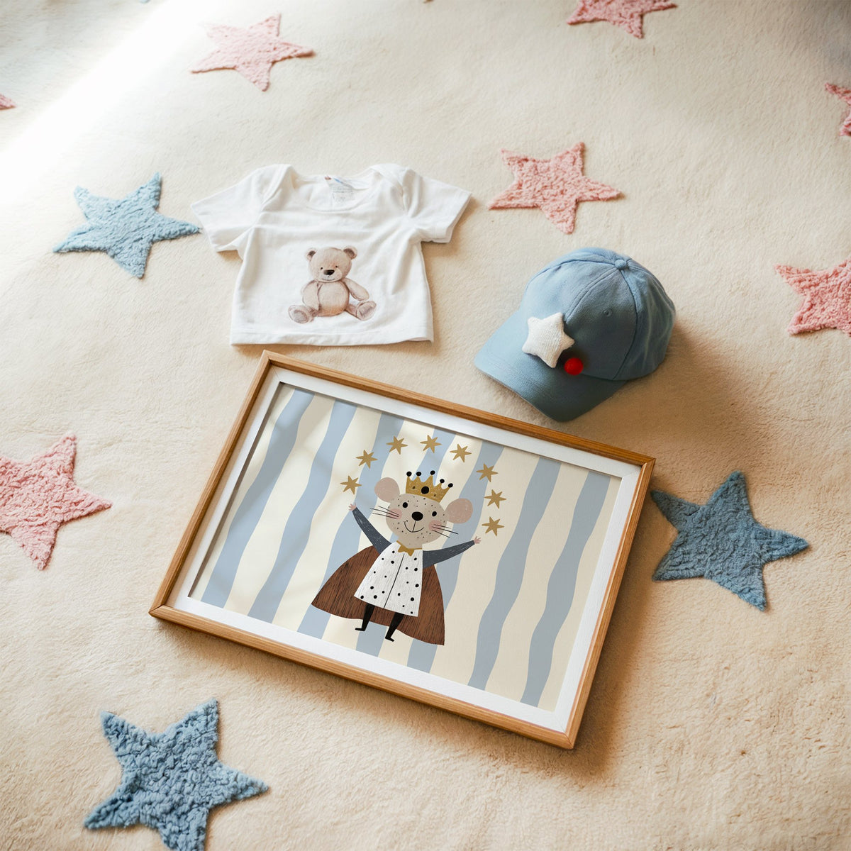 Landscape king mouse crown star arc nursery print in a matted oak frame on a star rug with a baby tee