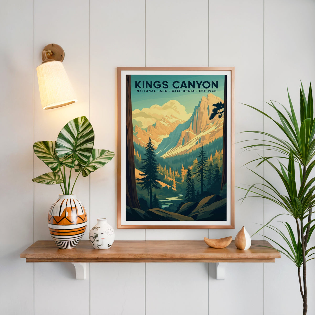 Kings Canyon National Park print in a copper frame above an oak shelf on white shiplap with a brass sconce