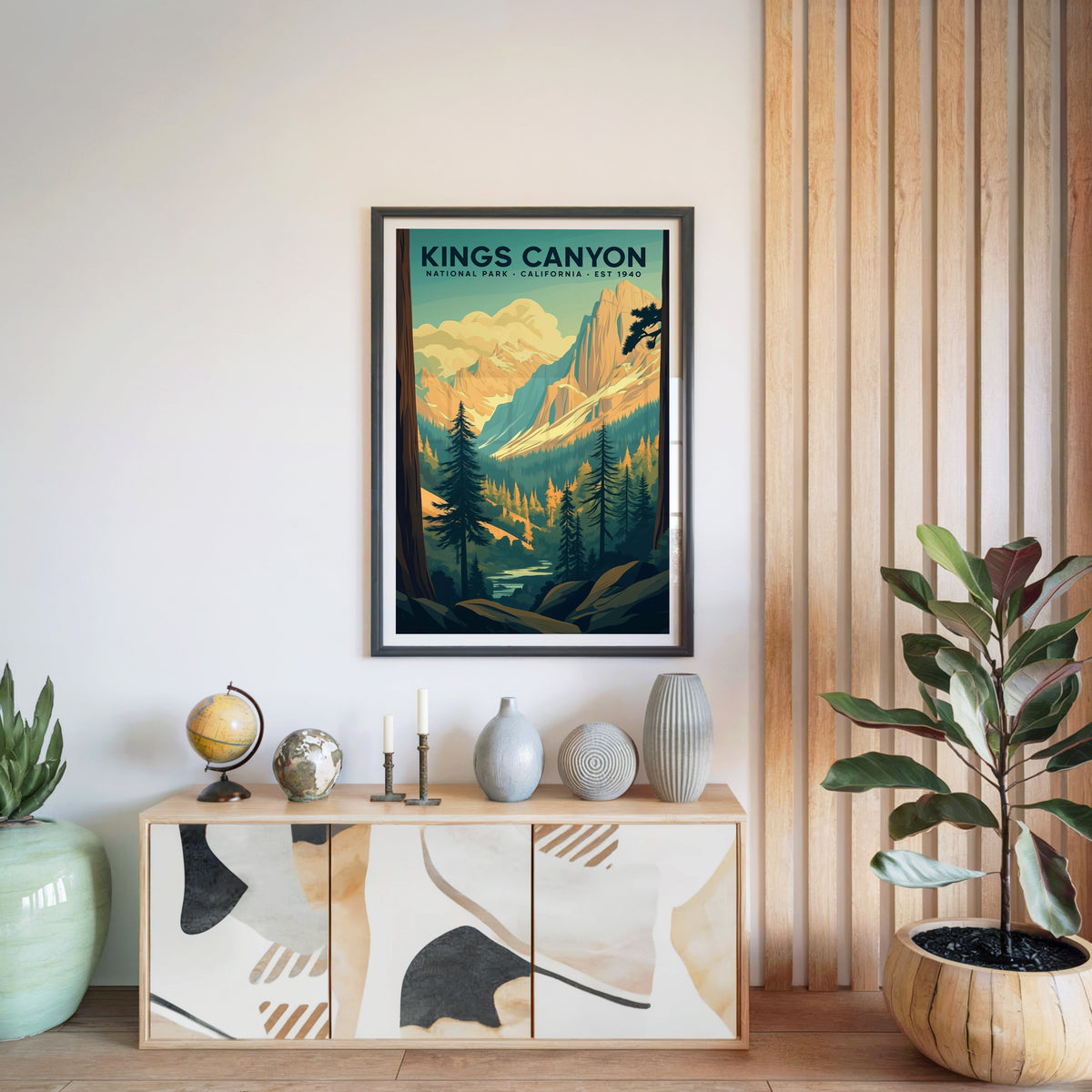 Kings Canyon National Park print in a black frame above a light wood sideboard with a globe and ceramic vases