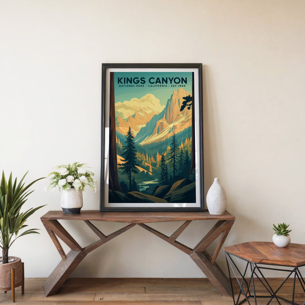 Kings Canyon poster in a black frame on an entryway console table beside white flowers and a yucca