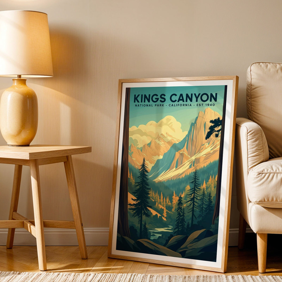 Kings Canyon print in an oak frame beside a cream armchair and an amber lamp in warm afternoon light