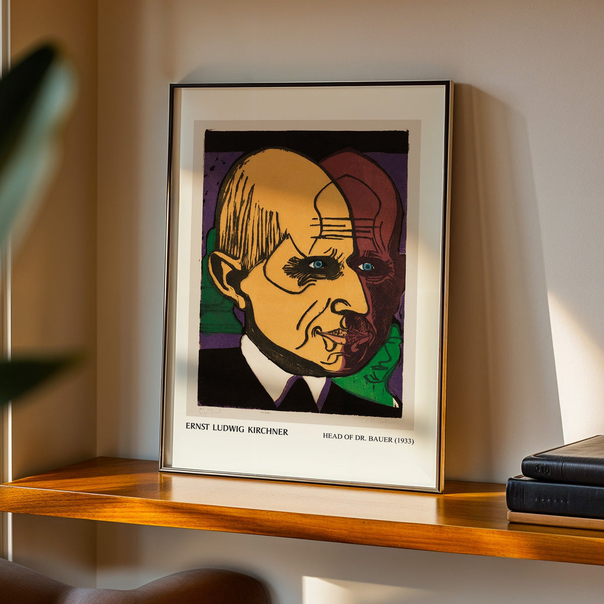 Head of Dr Bauer print in a black frame on a walnut shelf in evening light