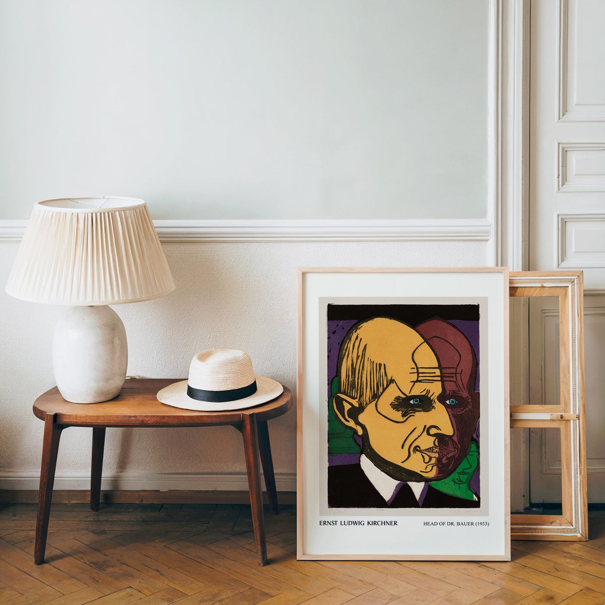 Kirchner poster in a light wood frame leaning by a bench and panama hat