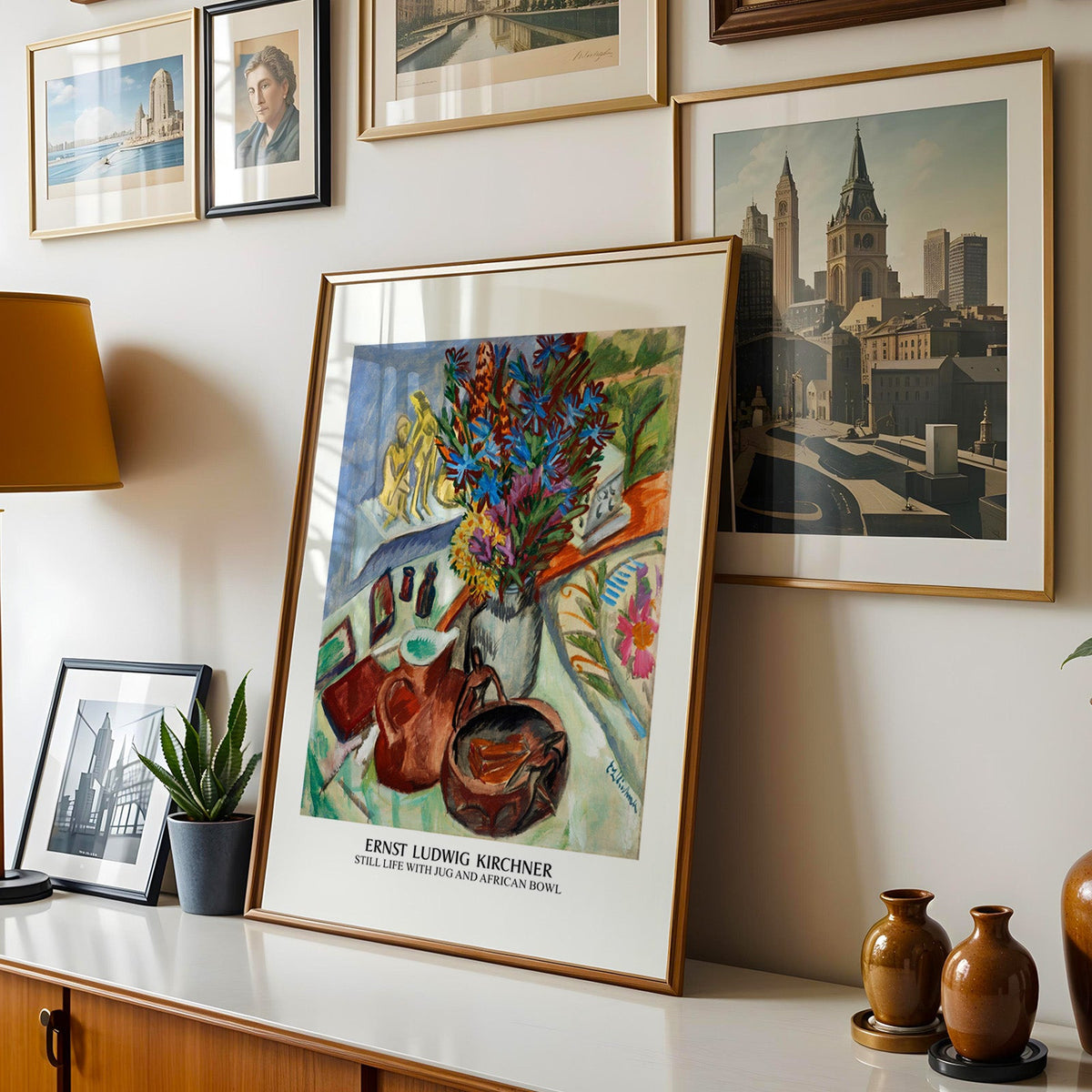 Kirchner still life shown in a gold frame leaning on a sideboard