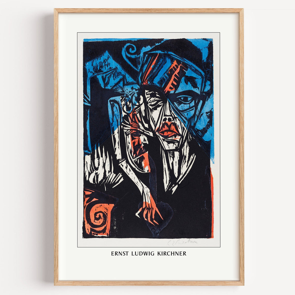 Kirchner woodcut head print in a light oak frame on a plain white wall