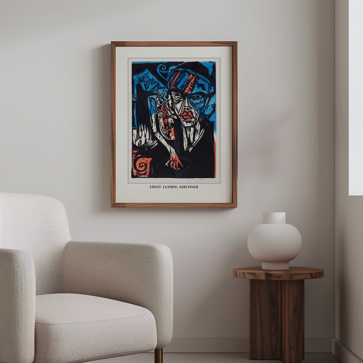 Expressionist woodcut in a slim walnut frame above a bouclé armchair