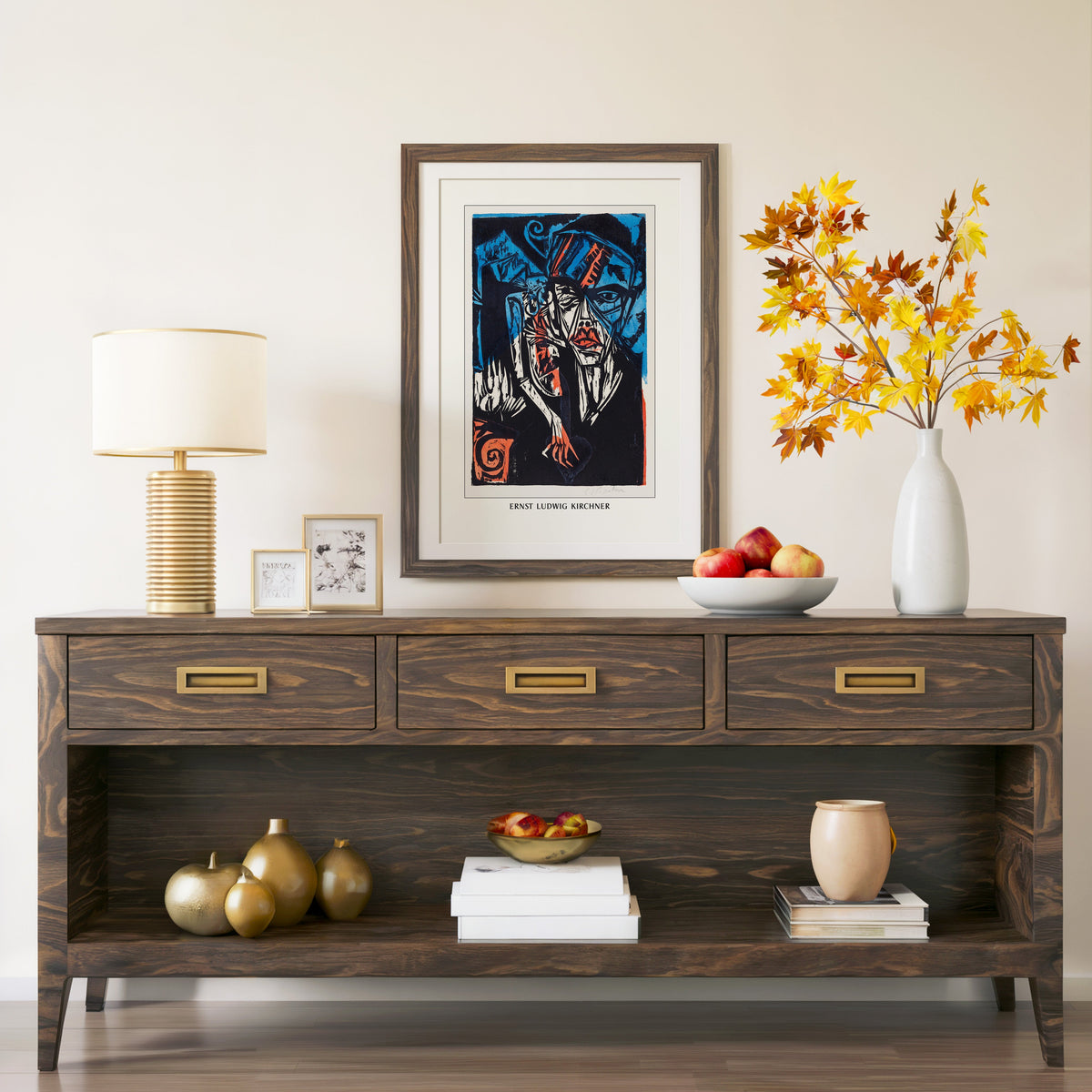 Woodcut head print in a walnut frame above a console with autumn branches