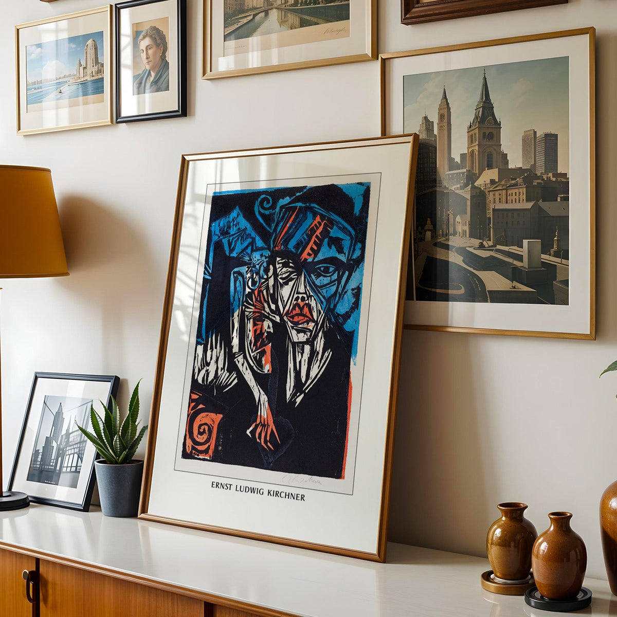 Kirchner woodcut shown in a gold frame leaning on a sideboard in a gallery wall