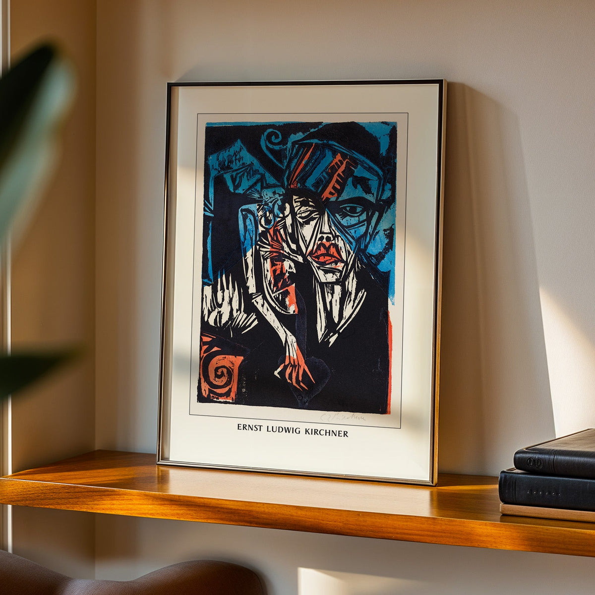 Kirchner woodcut in a black frame on a walnut shelf in warm evening light