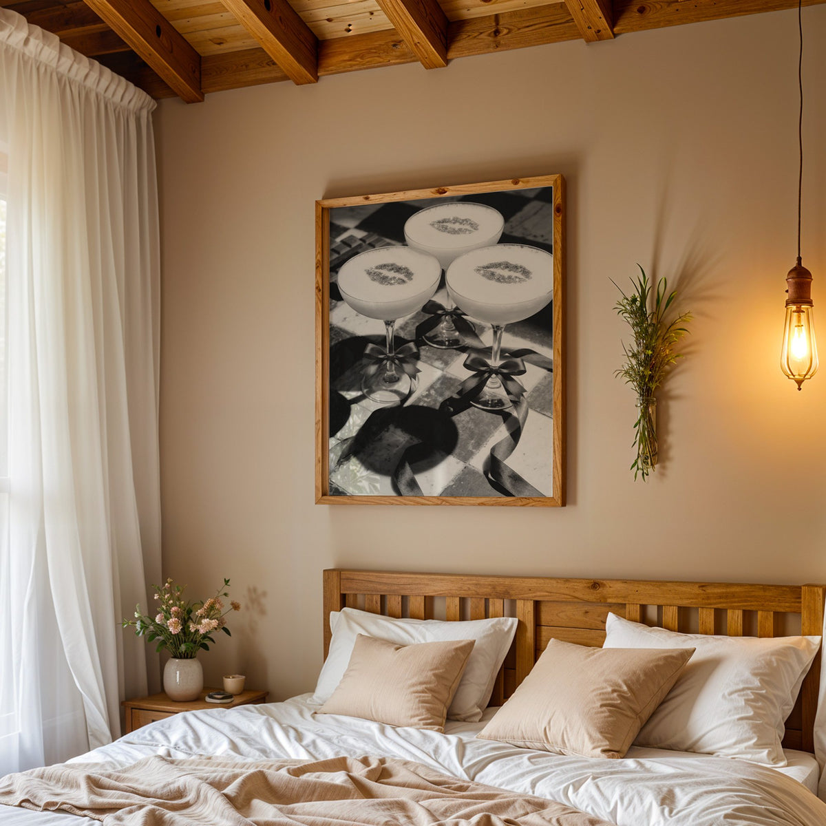 Three coupe cocktails with kiss marks and bows print in a pine frame above a wood headboard bed under a pendant bulb