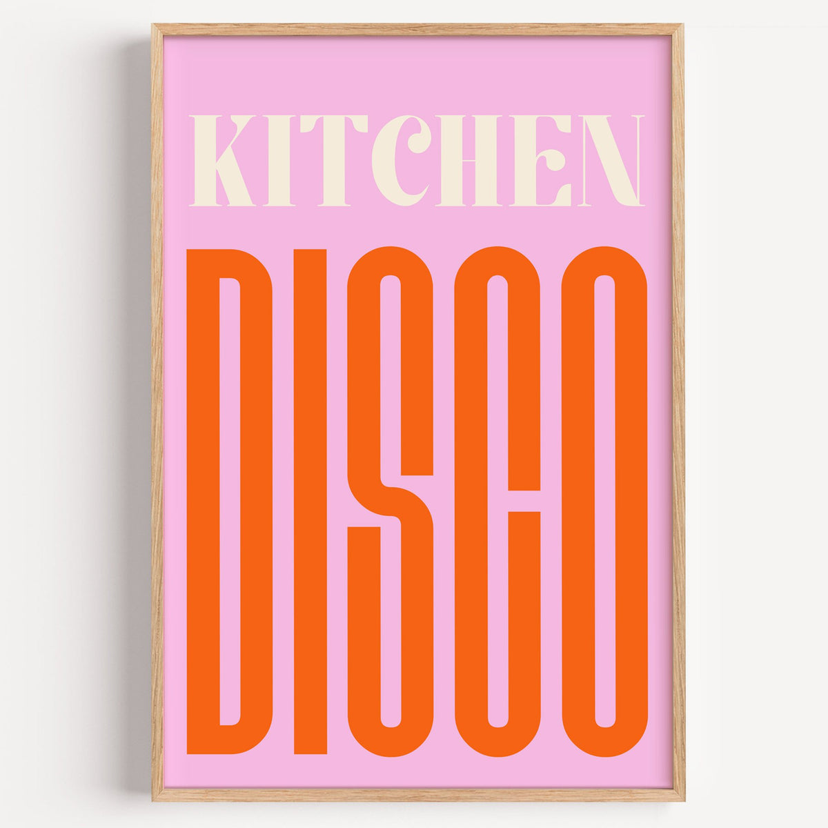 Kitchen Disco pink and orange type print in a light oak frame on a plain white wall