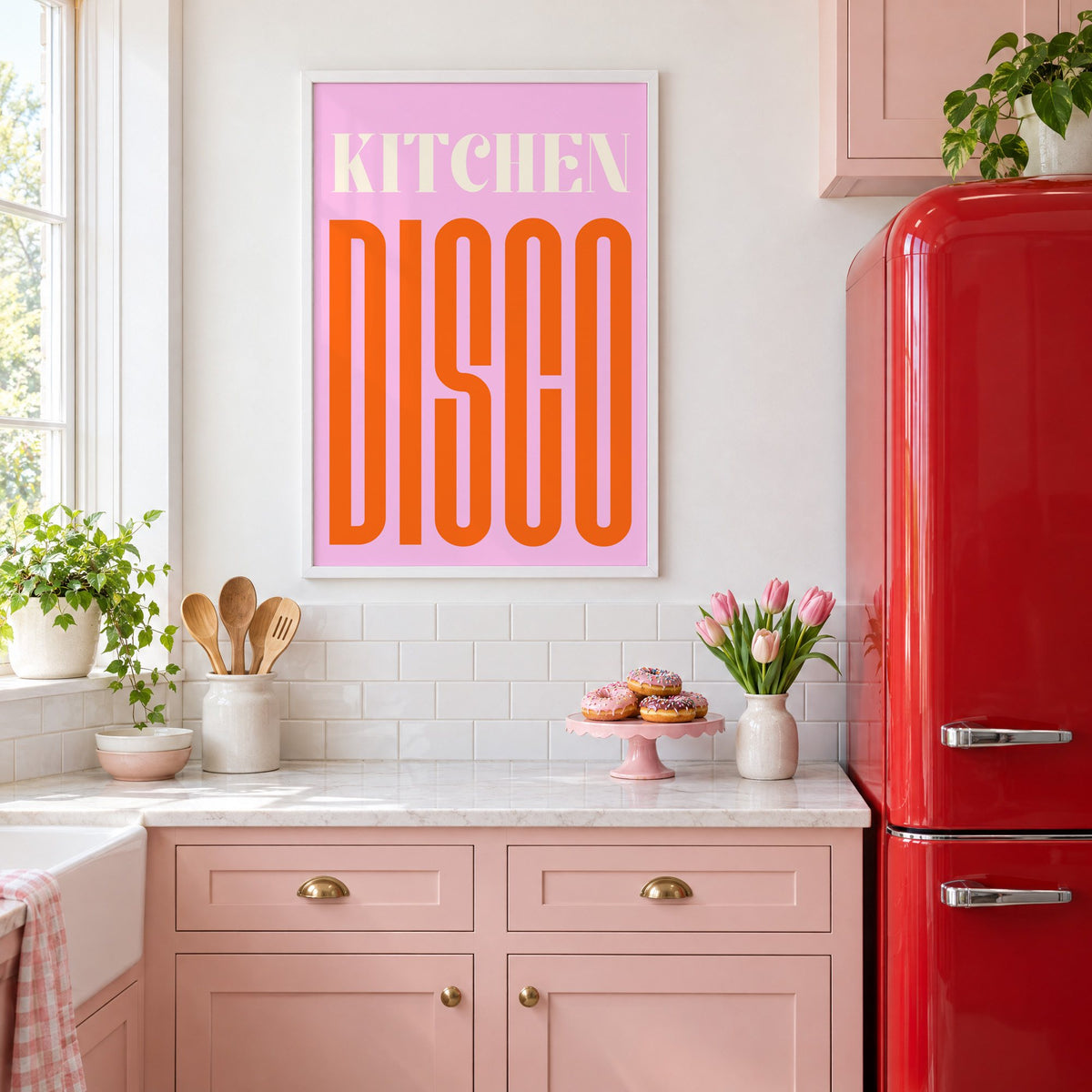 Kitchen Disco pink and orange type print in a white frame in a pink kitchen beside a red retro fridge