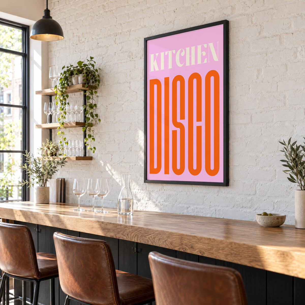 Kitchen Disco pink and orange type print in a black frame on a white brick wall above a wine bar counter