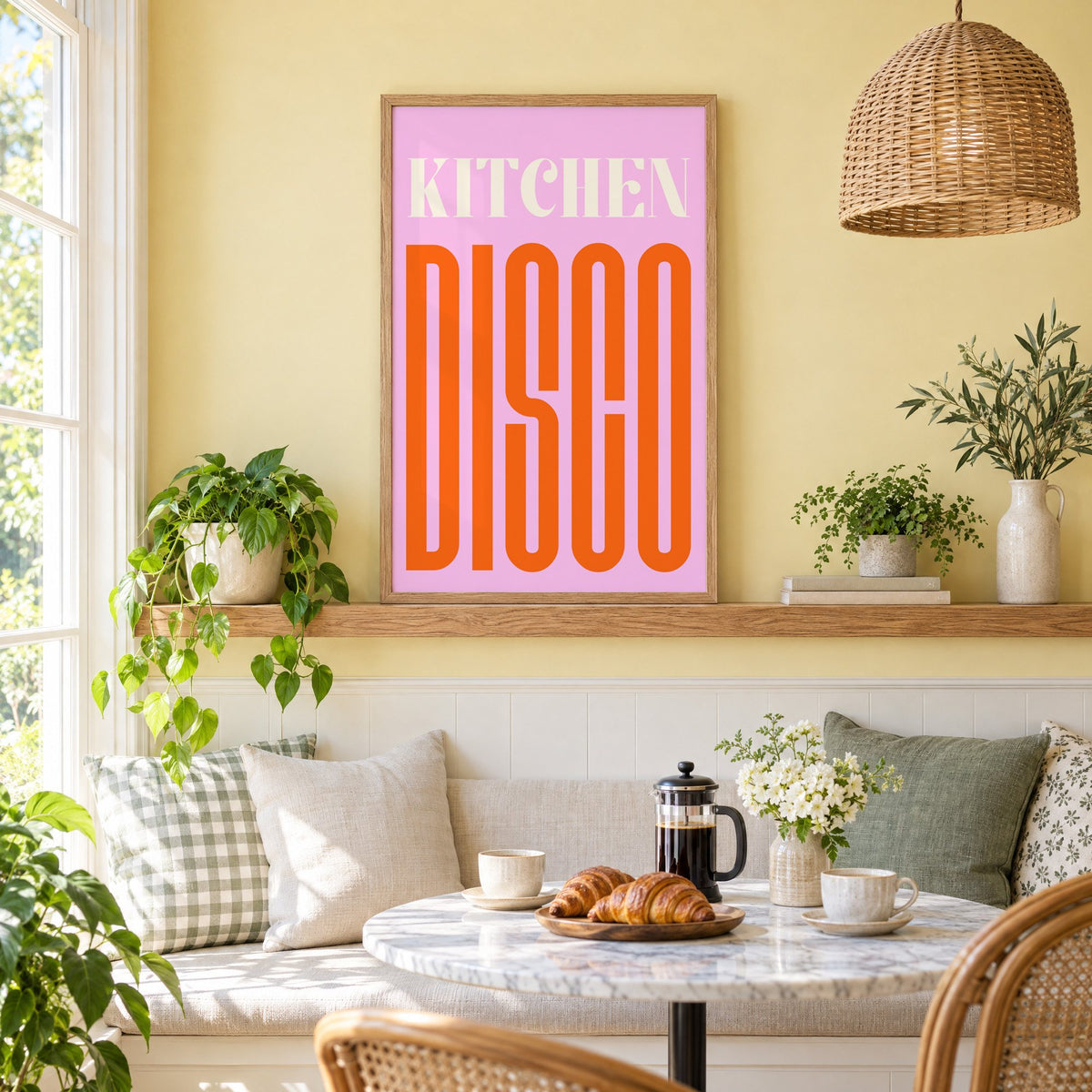 Kitchen Disco pink and orange type print in an oak frame on a picture ledge above a sunny breakfast nook
