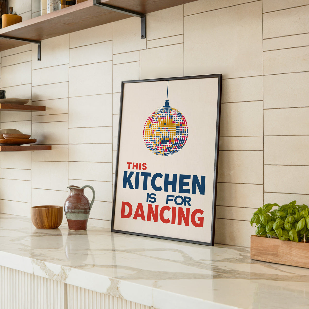 Kitchen Is For Dancing blue disco print in a black frame leaning on a marble counter in a tiled kitchen
