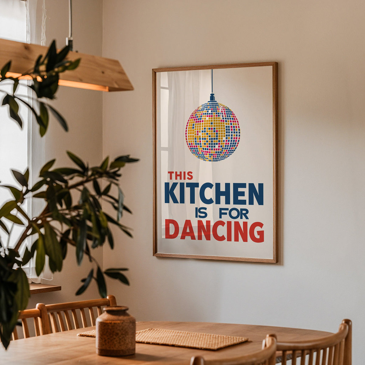 Kitchen Is For Dancing blue disco print in a walnut frame above a dining table with olive branches