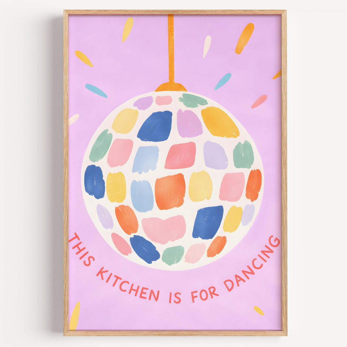 Pastel disco ball kitchen print in a light oak frame on a plain white wall