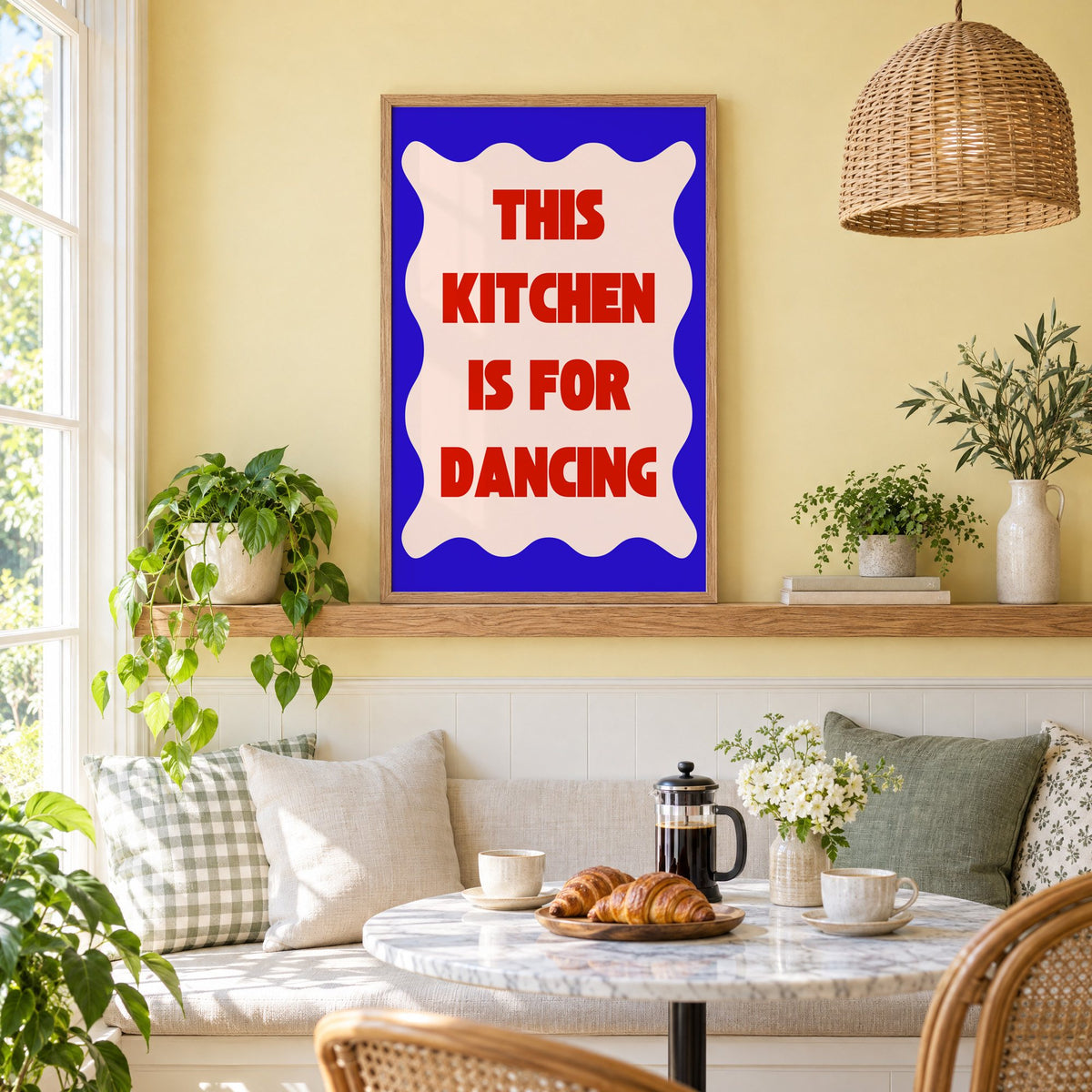 Kitchen Is for Dancing wavy blue print in an oak frame on a picture ledge above a sunny breakfast nook