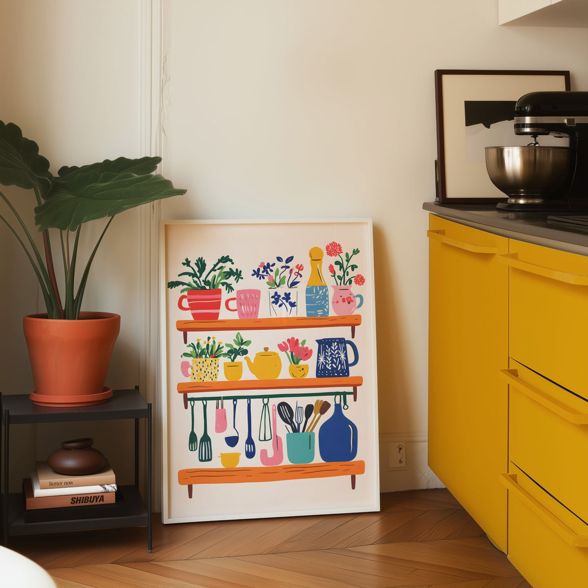 Kitchen shelf print in a white frame leaning on parquet beside a bright yellow kitchen