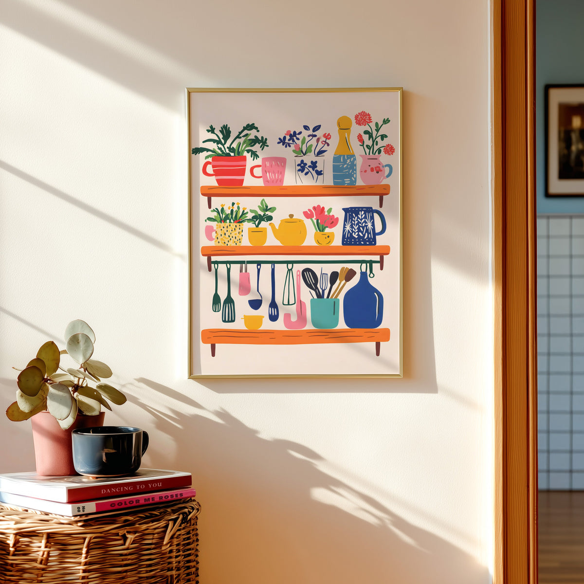 Kitchen shelf print in a gold frame above a basket of books and a pilea plant